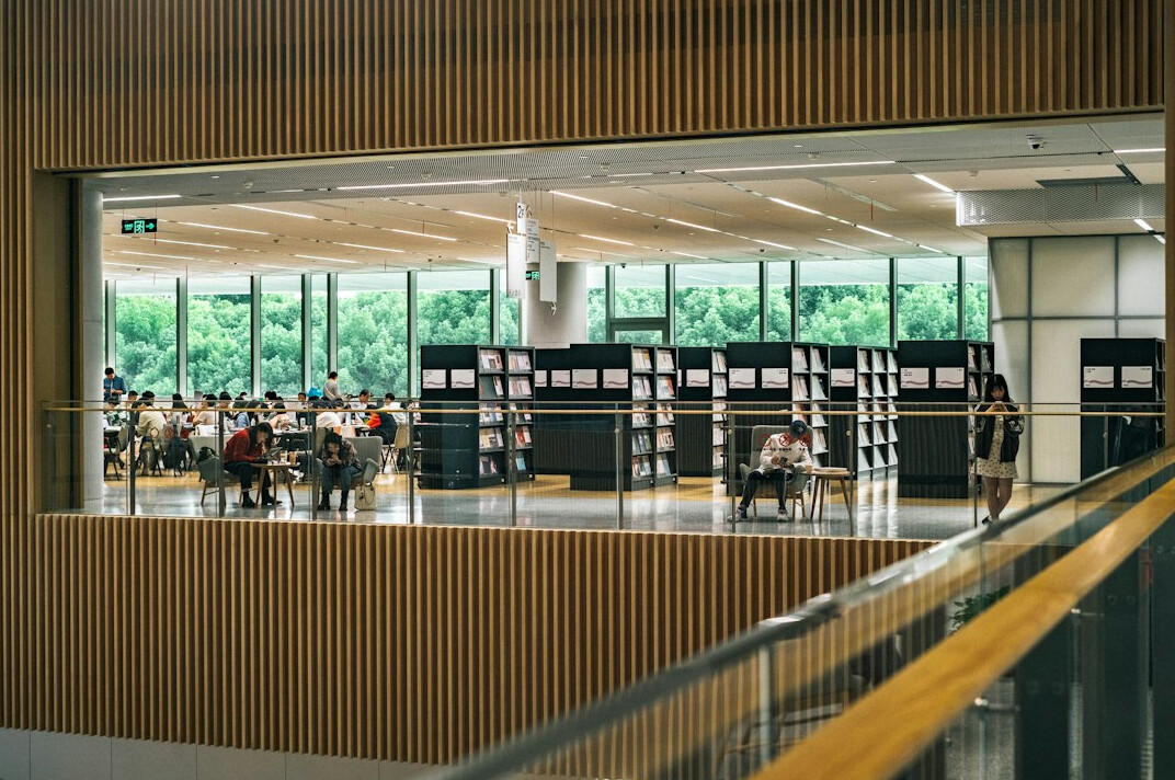 People queueing at the entrance of a modern library building