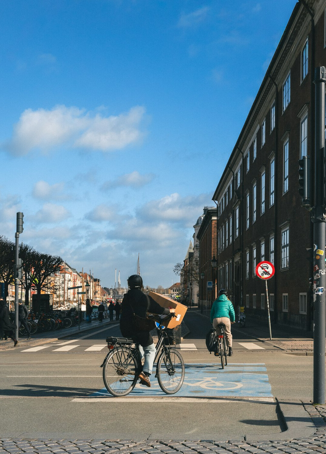 Two Danish people chatting while one takes notes on a city street