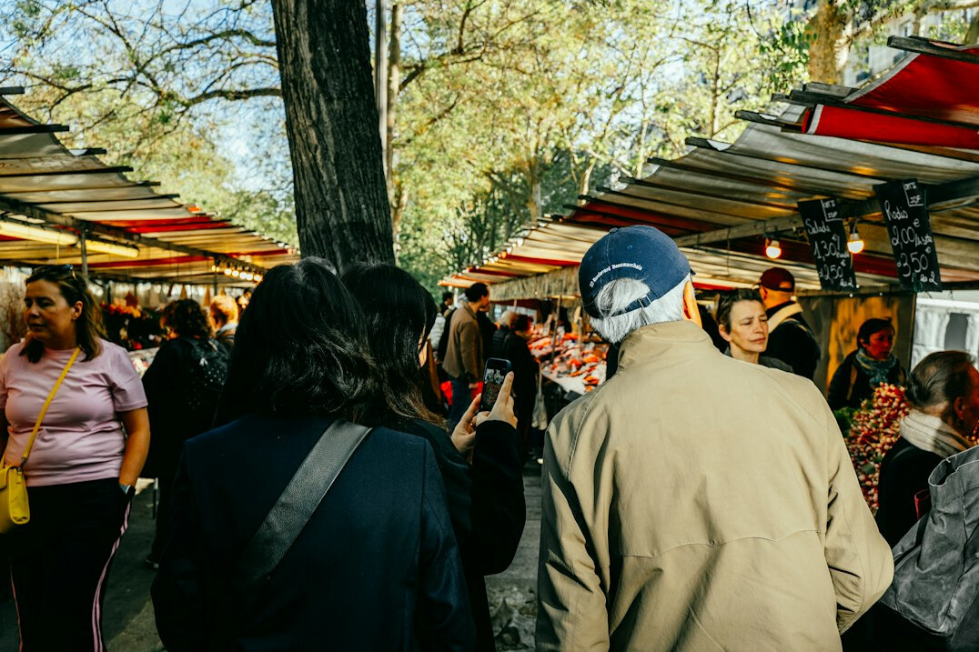 People waiting in line at an outdoor food market stall